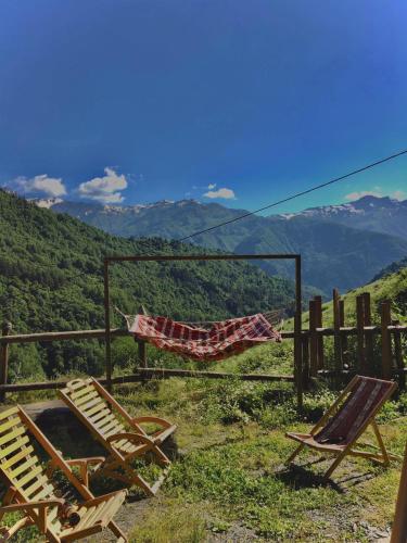 a couple of chairs sitting next to a fence at Qaldea Resort in Ushguli