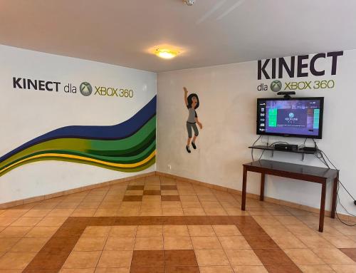 a room with a tv and a wall with a mural at Hotel ROK in Kraków