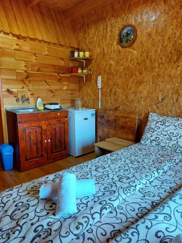 a bedroom with a bed and a sink in a cabin at Domaćinstvo Krstajić - Rural holiday in Žabljak
