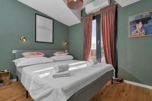 1 dormitorio con 1 cama grande y toallas. en Romantic stone house/City center/Beach!, en Makarska