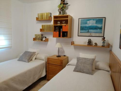 a bedroom with two beds and a table with a lamp at Casa adosada - Los Boliches - Fuengirola in Fuengirola