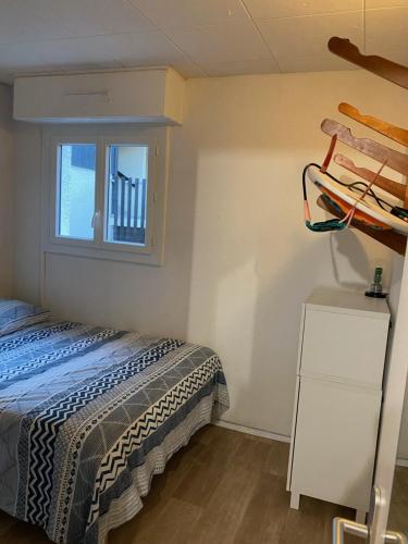 um quarto com uma cama e uma janela em Joli appartement proche océan et centre ville em Lacanau