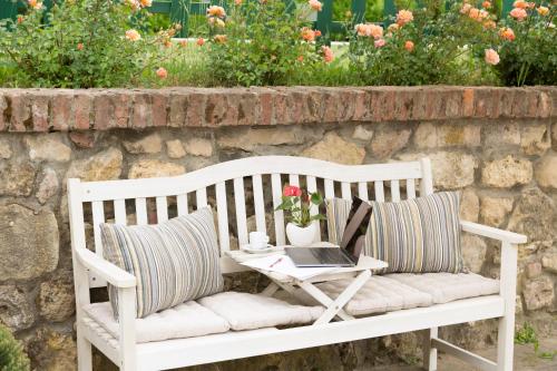 a white bench with a table with a laptop on it at White Tail Organic Farm in Orsara Bormida