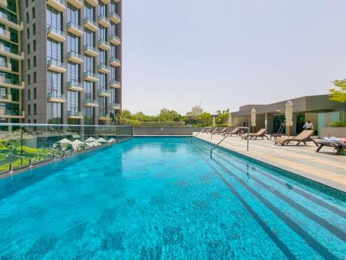 a large swimming pool next to a building at EDEN'S Homes & Villas - Atria Residences in Dubai