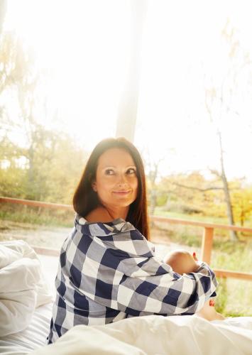 a woman is sitting on a bed at Gilleleje Badehotel in Gilleleje