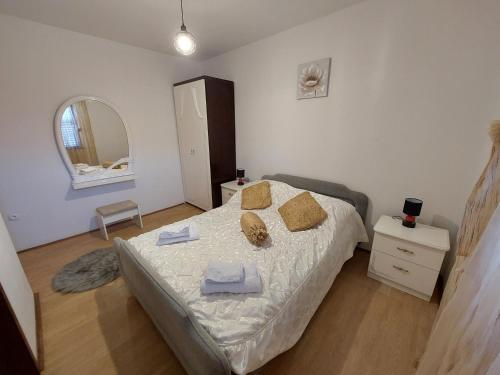 a bedroom with a bed with towels and a mirror at Apartment Dominik in Smokvica