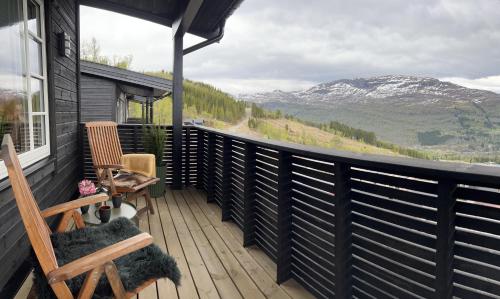 a deck with a chair and a view of a mountain at Panorama 15 - Beautiful mountain view in Sogndal