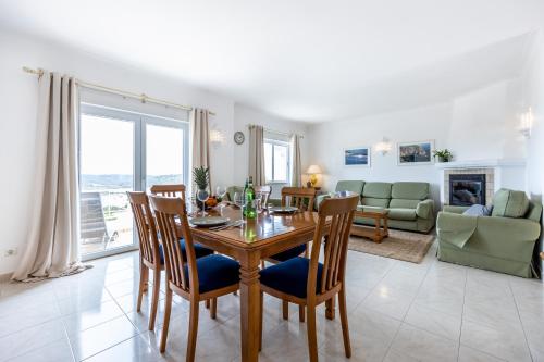 a dining room and living room with a table and chairs at Townhouse da Amarela in Budens