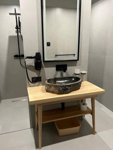a bathroom with a stone sink and a mirror at SAVOIE Apartments Bukovel in Bukovel