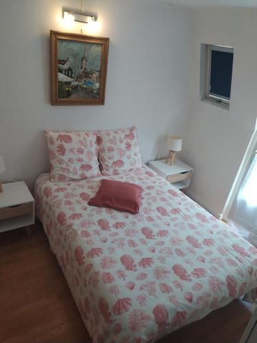 een slaapkamer met een bed met een rode bloemendeken bij Les pavés bleus - Cœur de Deauville in Deauville