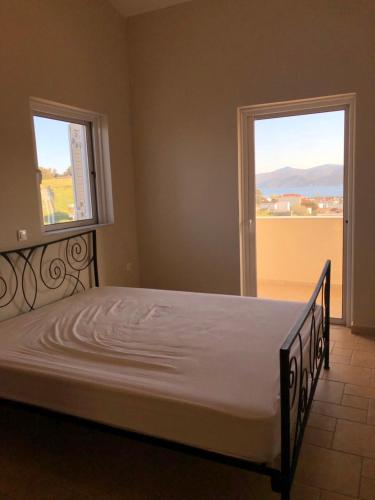 a large bed in a room with a window at Villa Petries Relaxed Holidays in Agioi Apostoli