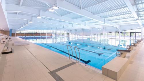 a large swimming pool in a large building at Cosy Aulnay- Paris Nord-Expo Villepinte in Aulnay-sous-Bois