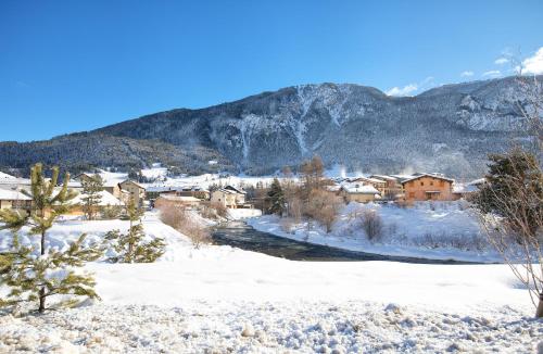 a village covered in snow with mountains in the background at Balcons B 014 - PARC NAT VANOISE appart 6 pers in Termignon