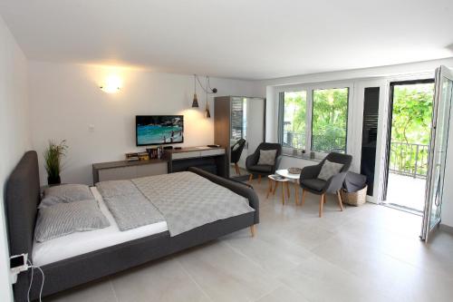 a bedroom with a bed and a living room at Modern Apartment Parenzana IZMA in Portorož