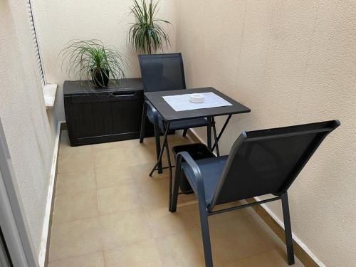 una mesa y una silla en una habitación con plantas en Casa Primi en La Nucía