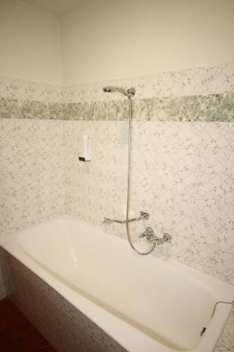 a white bath tub with a shower in a bathroom at Haus Kristall in Bach