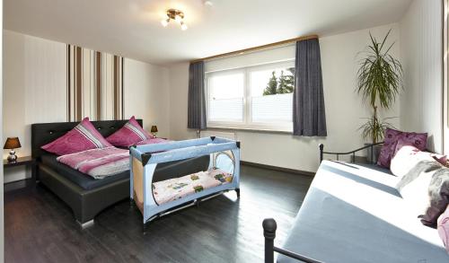 a bedroom with two beds and a baby crib at Kühne's 4 Sterne Komfort-Apartments in Braunlage