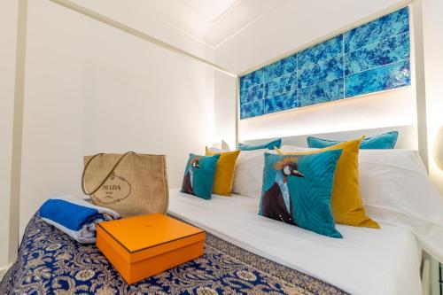 a bedroom with a bed with colorful pillows at Suite Apartment Capri con Jacuzzi in Piazzetta in Capri