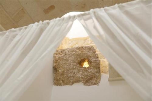 a white curtain with a rock in a window at AFFITTACAMERE I PACIORRA in Favignana