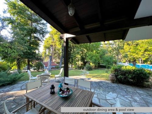 a wooden table and chairs on a patio at #Villa Niovi by halu! Sani Villas in Sani Beach