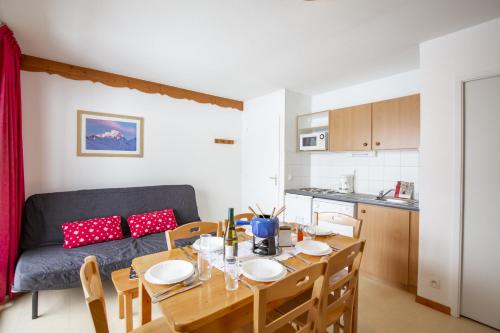 a kitchen and dining room with a table and a couch at Les Balcons PROCHE PARC NATIONAL VANOISE appartements 2 pieces 6 pers MONTAGNE ALP in Termignon