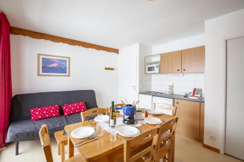 kuchnia i jadalnia ze stołem i kanapą w obiekcie Les Balcons PROCHE PARC NATIONAL VANOISE appartements 2 pieces 6 pers MONTAGNE ALP w mieście Termignon