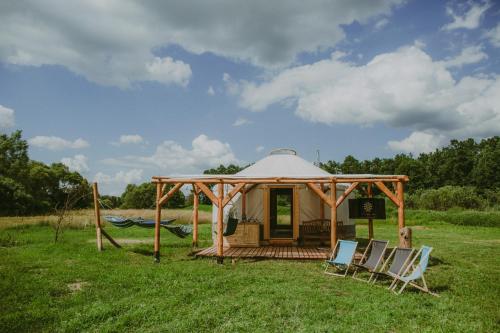ein Pavillon mit Stühlen und einer Hängematte auf einem Feld in der Unterkunft Szczere Pole in Karpacz