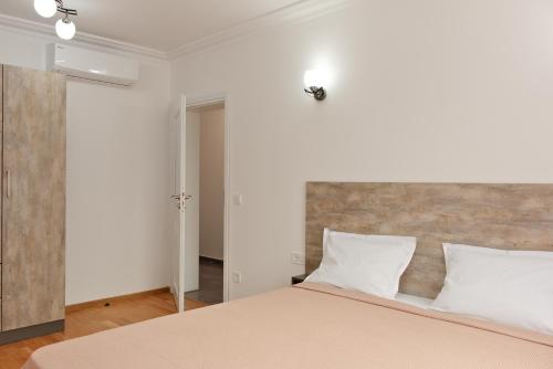 1 dormitorio con 1 cama grande con almohadas blancas en Апартамент за гости Дарива, en Smolyan