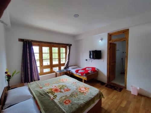 Habitación pequeña con cama y ventana en Jig Gyas Guest House, en Leh