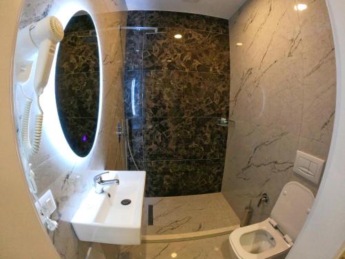 a bathroom with a sink and a toilet and a mirror at HOTEL BRAXTON in Bulqizë