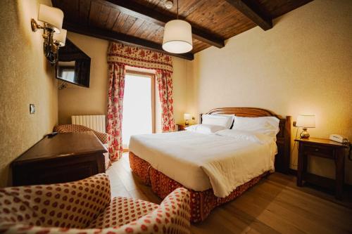 ein Schlafzimmer mit einem großen Bett und einem Fenster in der Unterkunft Hotel Jumeaux in Breuil-Cervinia