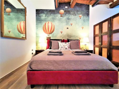 1 dormitorio con 1 cama grande y una pintura en la pared en Le mongolfiere, en Lucca
