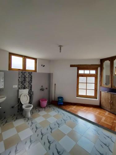 an empty bathroom with a toilet and a sink at Jig Gyas Guest House in Leh