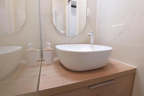 een badkamer met een witte wastafel en een spiegel bij Consul Apartment - Zadar city center in Zadar