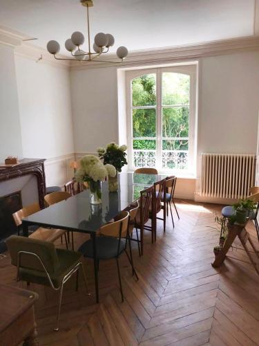 a dining room with a table and chairs and a window at La Villégiature in Coutances