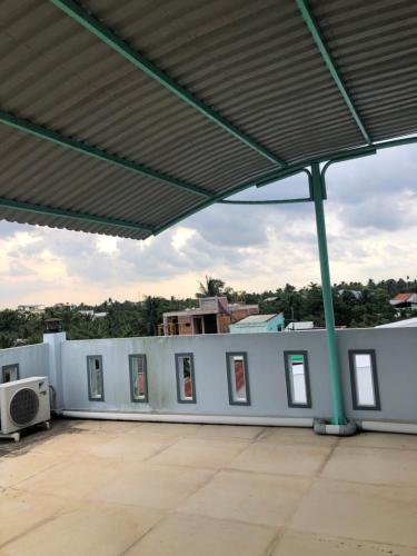 a white building with windows and a roof at Smiley House in Ấp Mỹ Hòa