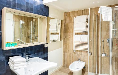 a bathroom with a sink and a shower at Hotel Petit Palais in Venice-Lido