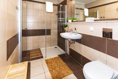 a bathroom with a toilet and a sink and a shower at VacationClub – Olympic Park Apartament B302 in Kołobrzeg