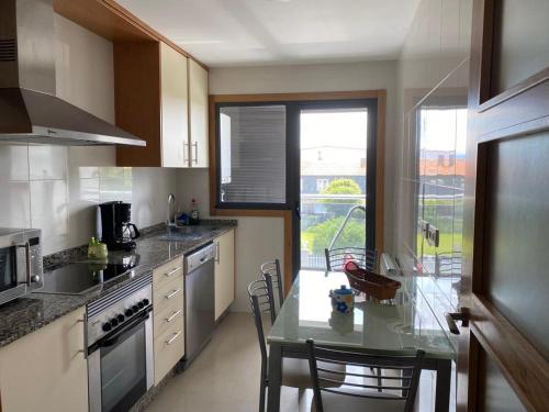 una cocina con mesa y algunas sillas. en Apartamento Cabodeiro - Illa de Arousa, en A Illa de Arousa