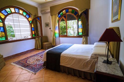 a bedroom with a bed and stained glass windows at Villa Achakar 32 in Tangier
