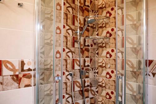 y baño con ducha y pared de azulejos. en Villa Parruccia, en Tolentino