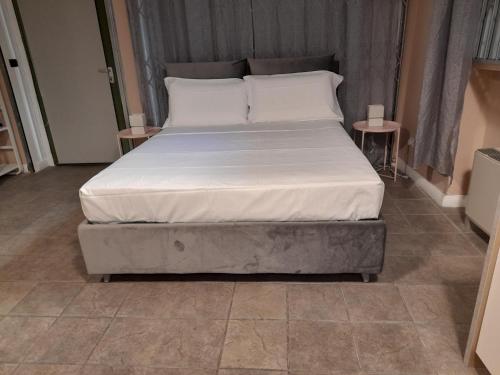 - un lit avec des draps et des oreillers blancs dans une chambre dans l'établissement Central Garibaldi Loft, a piedi a Palazzo Reale, à Turin