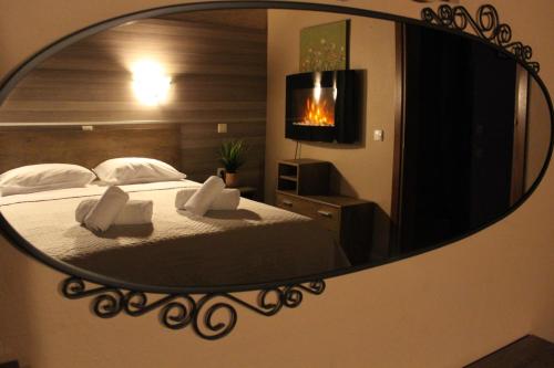 a mirror reflecting a bedroom with a bed and a television at Park Hotel Polykastro in Polykastro