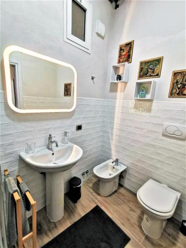 a bathroom with a sink and a toilet and a mirror at Le mongolfiere in Lucca