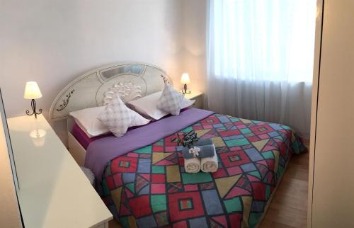 a bedroom with a bed with a colorful quilt at Apartments Tamara in Orebić