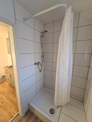 La salle de bains est pourvue d'une douche et de carrelage blanc. dans l'établissement Holly's Home, à Bad Homburg vor der Höhe