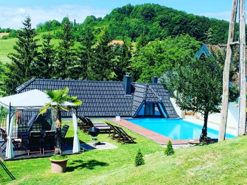 una casa con piscina junto a una montaña en Motel Heaven, en Zgornje Dobrenje