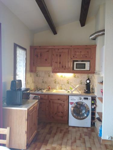 une cuisine avec un lave-linge et un micro-ondes dans l'établissement appartement T2 avec piscine, au Cap d'Agde