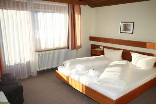 a bedroom with a bed with white sheets and pillows at Haus Kristall in Bach