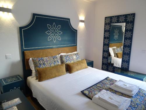 a bedroom with a large bed with a blue headboard at Casazul M&B in Cercal